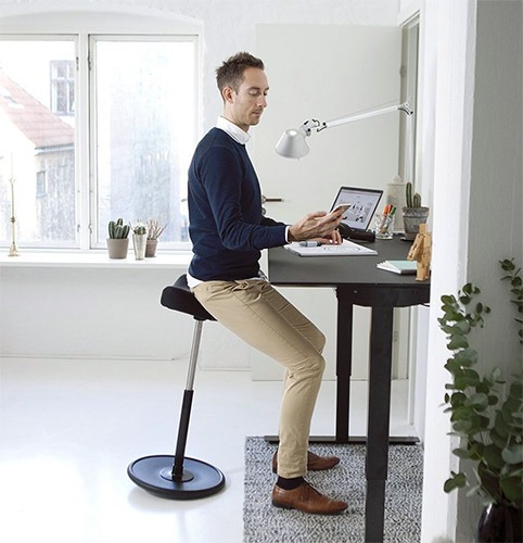 ragazzo seduto su un sgabello ergonomico